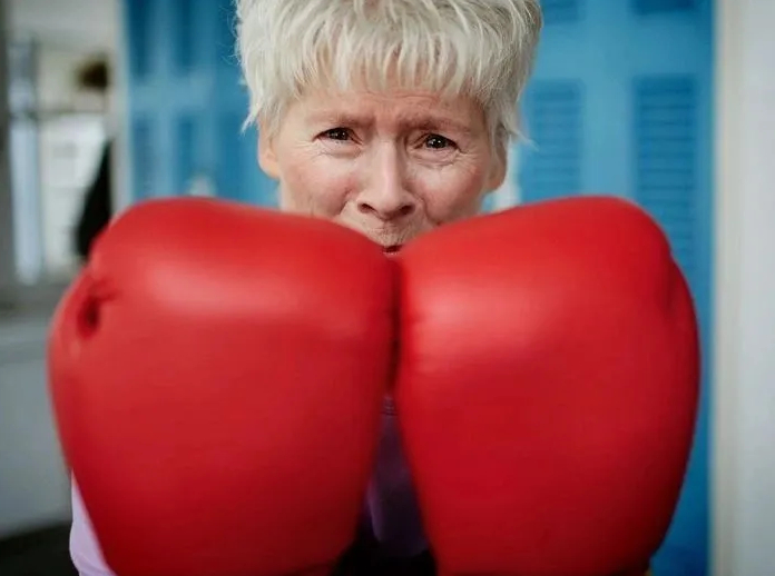 Rock Steady Boxing Lake Balboa participant boxing with red gloves